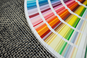 Color swatch fan deck on textured woven mat, ideal for interior or graphic design ideas