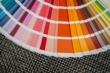Cool toned paint swatches fan on woven fabric background for decor and color selection use