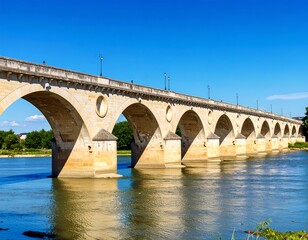 Stone arch bridge over a river under a clear blue sky