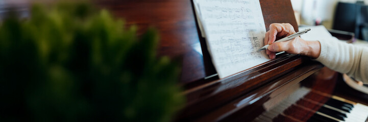 Wide banner of musician annotating sheet music
