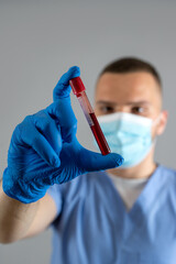 Man doctor or nurse hold blood test for result coronavirus 2019-ncov isolated on grey