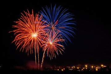 Fireworks bursts of red and blue over night city