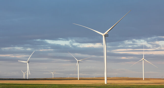 Windmills in a rural area during sunset, renewable energy green technology industry