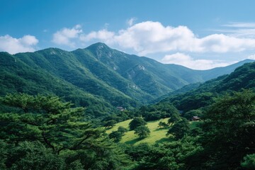 Obraz premium Lush mountains surrounded by bright greenery and clear blue sky