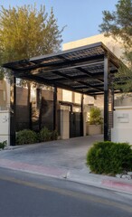 Modern, dark-metal carport over driveway,  beige house