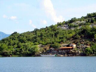 Fototapeta premium Charming Restaurant by the Tranquil Waters of Skadar Lake in Montenegro During a Sunny Afternoon