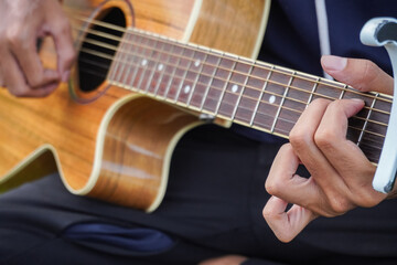 Obraz premium Man's hand is plucking the guitar strings. Man playing guitar.