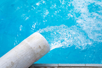 Pipes channel water to the swimming pool. Water flows from the pipes.
