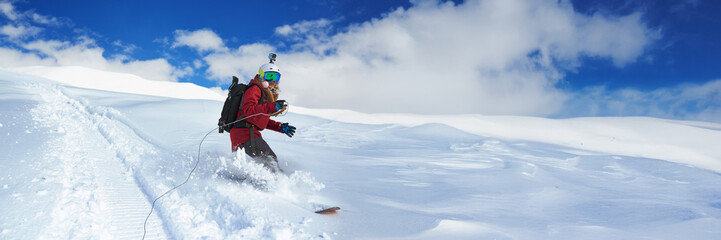 Snowboarder Riding Downhill on a Sunny Day Wide Banner