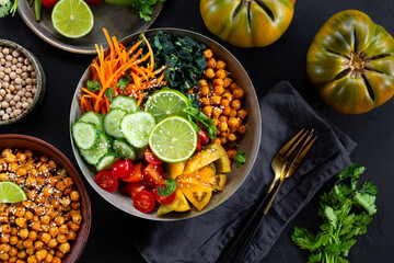 Buddha bowl - vegetarian bowl with chickpeas and fresh vegetables on the black table top view