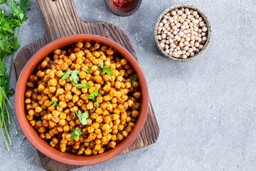 Vegetarian food. Roasted chickpeas with spices in a bowl on grey background top view copy space for...