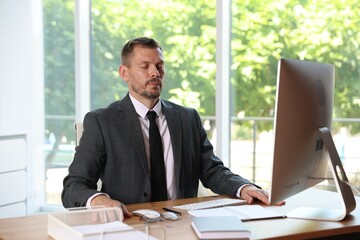 Panic attack. Businessman calming himself down at workplace in office