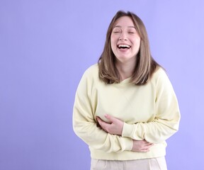 Attractive woman laughing on violet background. Positive emotion