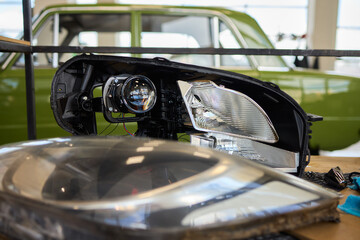 Automotive Headlight Components with a Vintage Car Present in the Background for Display