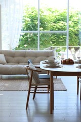 Beautiful table setting, chairs and decor in dining room. Interior design
