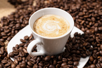 Coffee late cup and roasted beans on table
