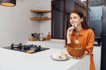 Young woman enjoying a healthy salad in a modern kitchen, showcasing wellness and fresh ingredients...