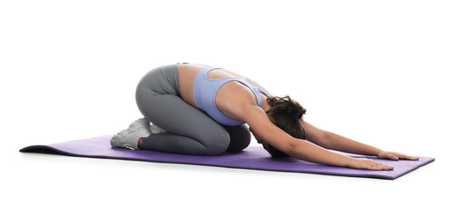 Teenage girl in sportswear stretching on mat against white background
