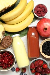 Obraz na płótnie Canvas Superfood. Bottles with tasty smoothies and ingredients on light wooden table, flat lay