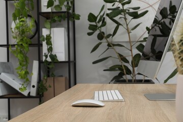 Biophilic interior design. Stylish workplace with computer and houseplants in office