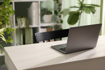 Biophilic interior design. Stylish workplace with laptop and houseplants in office