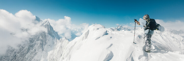 Snowboarder on Snowy Mountain Peak Wide Banner