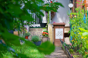 Charming house entrance with organic waste bin and tomato patch