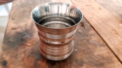 Empty Steel Tumbler on a Wooden Table