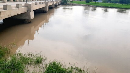 Muddy River Flowing Under a Concrete Bridge