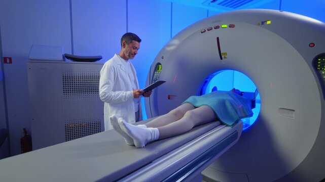 Medical worker standing confidently near MRI tunnel while female patient resting on table. Overseeing post-scan procedure inside professional medical imaging center. Patient lying on CT, PET, or MRI