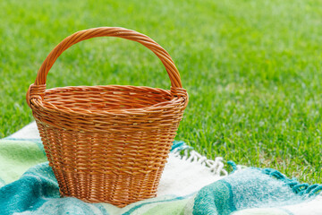 Picnic basket on a green lawn under sunny skies, ready for an outdoor meal