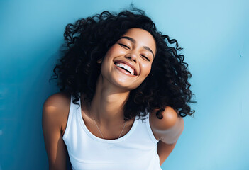 Young woman model in white tank top with necklace against blue background.