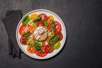 Fresh burrata served on slices of colorful tomatoes