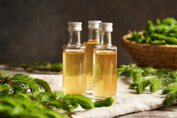 Three glass bottles of herbal syrup made with young raw spruce tips collected in spring and brown sugar