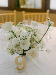 Elegant floral centerpiece on dining table with number nine for celebration at golden hour