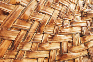 Woven rattan texture closeup. Natural brown wicker surface with traditional basket weaving pattern....