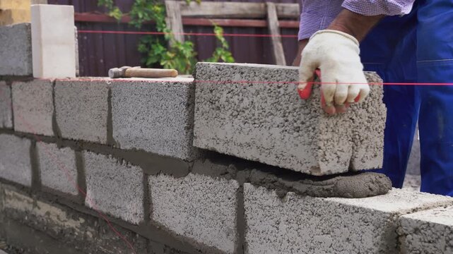 Bricklayer laying out a brick wall