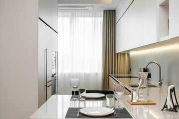 Modern kitchen setting with an elegant dining arrangement in a bright, spacious urban apartment during daytime