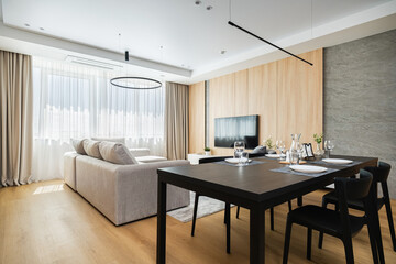 Modern living room and dining area in a bright, stylish apartment showcasing minimalist design