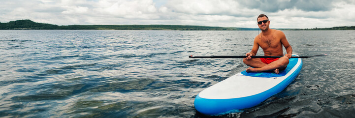 Man Relaxing on Paddleboard Wide Banner