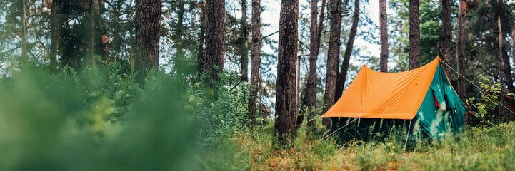 Orange Tent in Forest Wide Banner with Copy Space