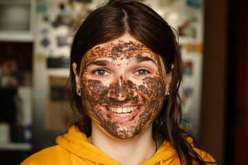 a woman with a beautiful smile, wearing a facial mask. a coffee scrub and a face peeling ritual....