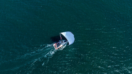 Aerial View of Sailboats Racing on Open Water with Gentle Horizon. High-angle shot of multiple...