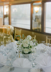 Elegant table setting with floral centerpiece on a dining boat in the afternoon