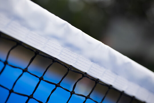 Padel tennis net close up. Blue outdoors court.