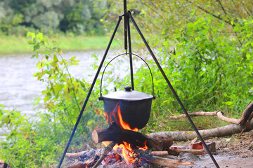 Camping pot over smoldering fire