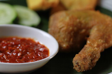 Indonesian fried chicken with sambal red chili, tofu,cucumber and tempe