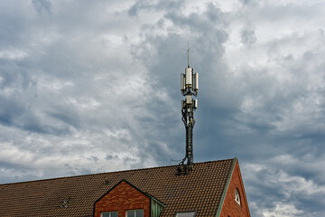 Rooftop mobile cell tower with antennas and white radio units