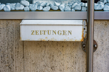 Rusty metal newspaper box with golden Zeitungen letters