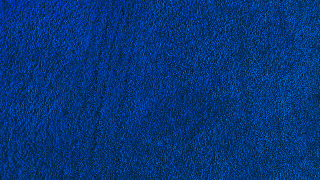 High resolution blue carpet texture. close up detail of wool or nylon flooring fibers for seamless background or interior design mock up.